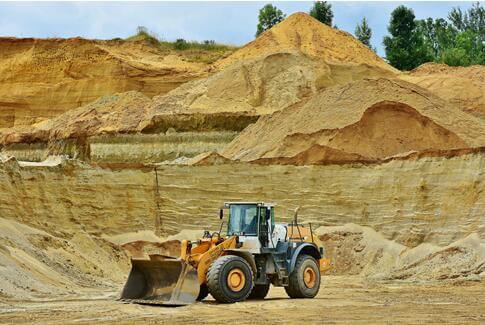This picture shows a yellow forklift working in an open pit mine